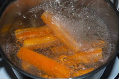 Parlak turuncu havuç, tencerede pişiyor.