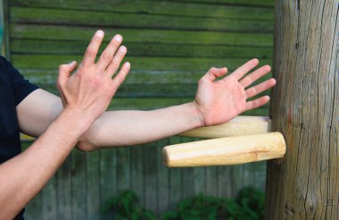 Çin dövüş sanatı olan Wing Chun Kung Fu dövüşçüsü tahta kukla üzerinde çalışıyor.