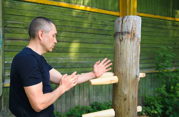 The Chinese martial art of wing Chun Kung Fu fighter is training on the wooden dummy