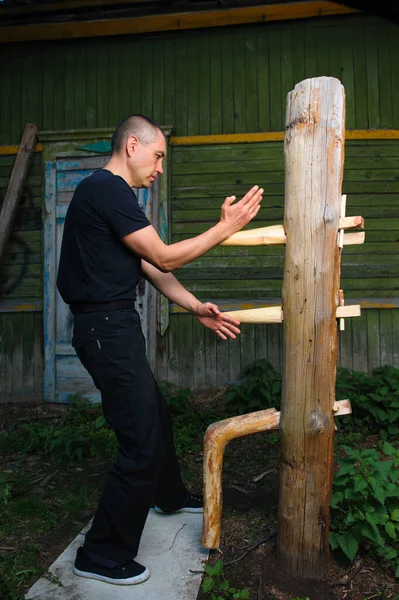 The Chinese martial art of wing Chun Kung Fu fighter is training on the wooden dummy