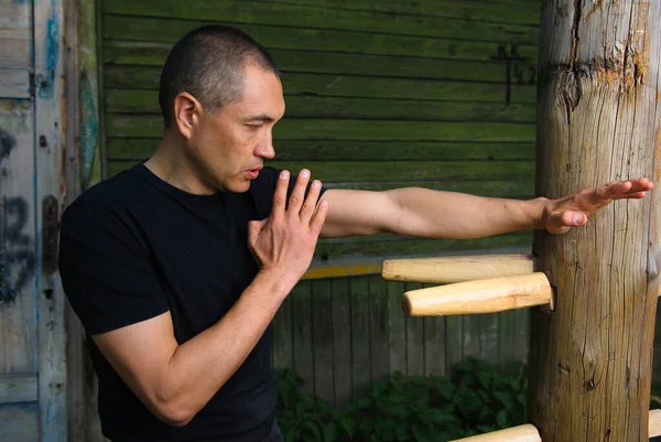 The Chinese martial art of wing Chun Kung Fu fighter is training on the wooden dummy