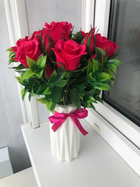 Beyaz bir vazoda bir buket parlak gül.