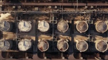 Petrol rafinerisi veya kimya fabrikası ve enerji santrali üzerinde birçok depolama tankı ve boru hattı olan havadan aşağı görüş. 4K UHD çözünürlüklü İHA ile çekildi.