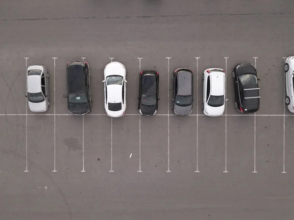 Вид зверху на машину, що їде на парковці. Вид зверху на літаючий безпілотний автомобіль, що рухається і стоїть на парковці в сучасному місті. Автомобільний рух і концепція паркування — стокове фото