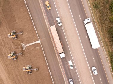 Yeni yol inşaatında çalışan kazıcıların hava görüntüsü. Yukarıdan aşağıya İHA atışı.