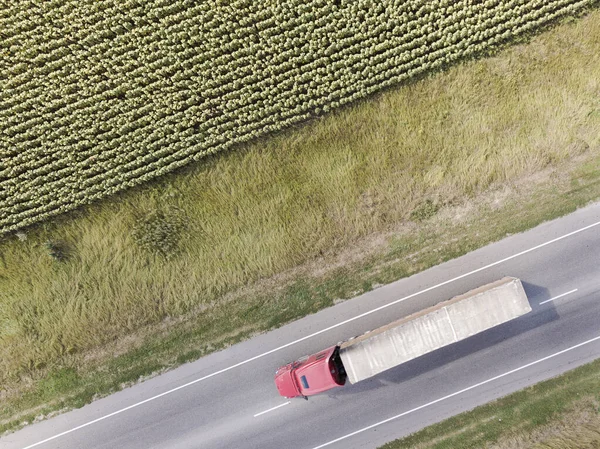 Letecký Top Pohled na kamion s nákladním návěsem Pohybuje se po silnici mezi poli farmy. Rostovská oblast. — Stock fotografie