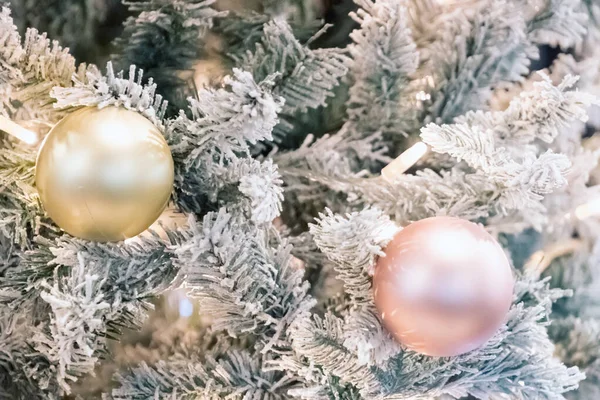 Frohe Weihnachten und ein gutes neues Jahr Urlaubspostkarte. Goldene Kugeln auf Fichten, Kugeln und Girlanden, die an Tannenzweigen vor festlicher Kulisse hängen. Weihnachtlicher Hintergrund. — Stockfoto