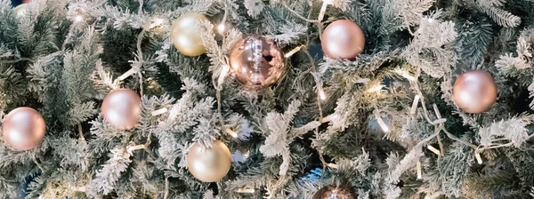 Bolas y guirnaldas colgando de las ramas de pino en el telón de fondo festivo. Bolas de oro en abeto. Fondo de Navidad. Feliz Navidad y Feliz Año Nuevo postal de vacaciones. Decoración festiva — Foto de Stock