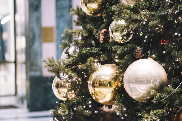 Festlig utomhus dekorativa jul ljus bakgrund. Julgran gren dekorerad med grannlåt, bollar på arkitektoniska landmärke bakgrund. — Stockfoto