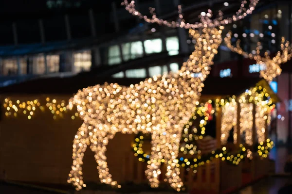 Rozmazaná světla vánoční instalace - rozostřená světla jelenů na pozadí nočního města. Instalace vánočního jelena v Miláně — Stock fotografie