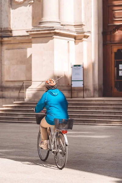 Milán, Italia - 27 de septiembre de 2020: Mujer mayor montando bicicleta en el centro de Milán. La vejez activa, las personas y el estilo de vida - señora mayor haciendo deportes exersices en la ciudad — Foto de Stock
