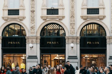 Prada logosu ve Milans Moda Bölgesi, Montenapoleone bölgesindeki lüks moda dükkanının dışı. Yoldan geçen insanlar. Prada İtalyan lüks moda evi Milan, İtalya - 31.10.2019.