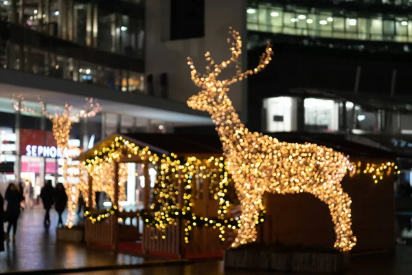 Rozmazaná světla vánoční instalace - rozostřená světla jelenů na pozadí nočního města. Vánoční instalace jelenů. Milan, Itálie - 25.12.2019 — Stock fotografie