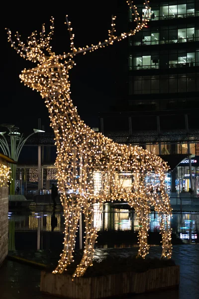 Vánoční instalace - jelen na nočním městském pozadí. Instalace vánočního jelena v Miláně — Stock fotografie