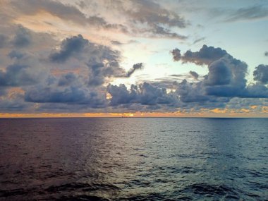 Güneşin doğuşu bulutlu gökyüzü ve güzel okyanus