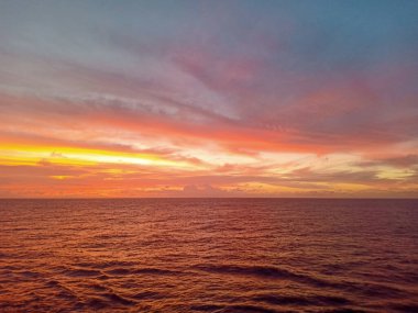 Okyanusta güzel gün batımı ve bulutlu gökyüzü