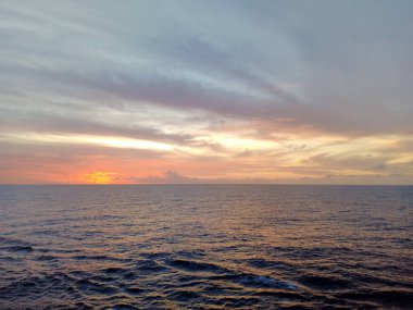 Okyanusta güzel gün batımı ve bulutlu gökyüzü