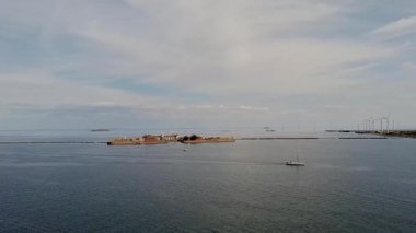 Danimarka sterbro sep 2 2024 Açık Sahil Sahnesi Ada, Rüzgar Türbinleri ve bir Yelkenli Tekne