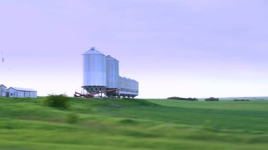 Yakın zamanda Alberta Kanada 'daki Kanada ovalarında tarım endüstrisini ön plana çıkaran büyük metal tahıl ambarları ekilen bir sürüş..