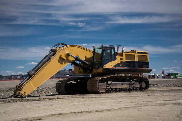 A large excavator sits in an urban development as this piece of machinery is assembled and requires maintenance.