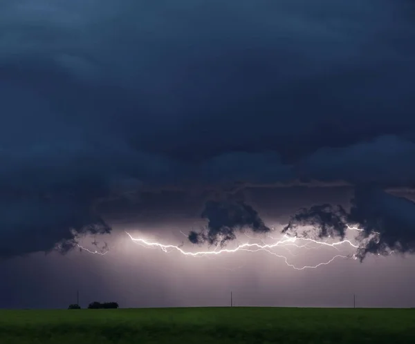 A thunderstorm on the canadian prairies with lightning over a farmhouse.