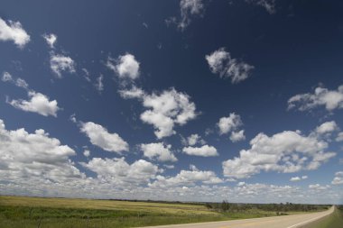Kuzey Alberta 'da bir otoban boyunca derin mavi gökyüzünün altında manzaralı bir rota..