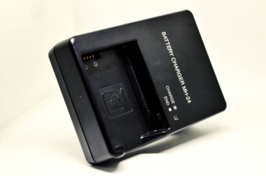 Beyaz zemin üzerinde izole kamera için pil şarj edici.