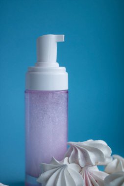 Mavi arka planda parlak kremalı güzel bir şişe.