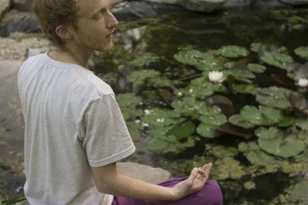 Handsome Male Buddhist Meditating Lake Lilies — стокове фото