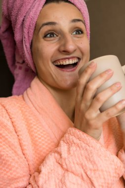 Güzel esmer kız mutfakta kahve içiyor.