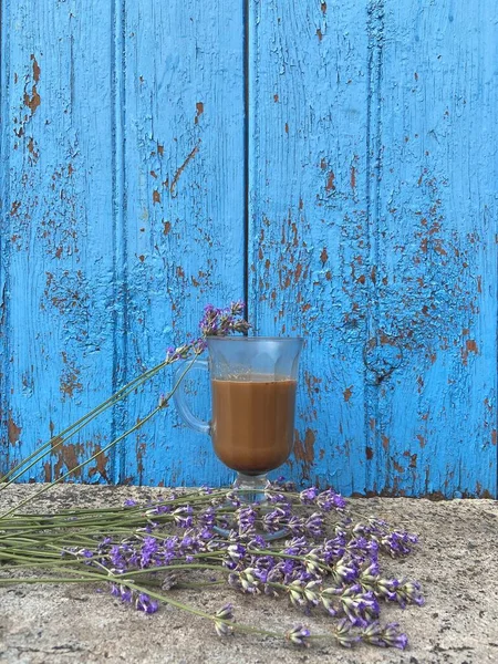 爱尔兰杯子里的自制咖啡站在混凝土上 旁边的薰衣草放在蓝色的旧木板背景上 — 图库照片