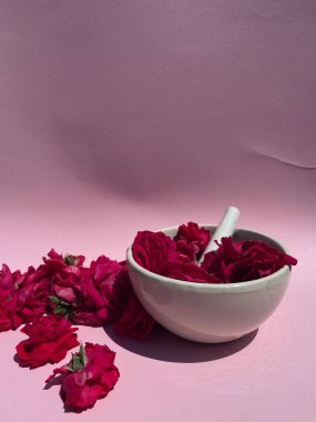 Beyaz harç ve tokmak pembe arka planda parlak kırmızı güllerle dolu