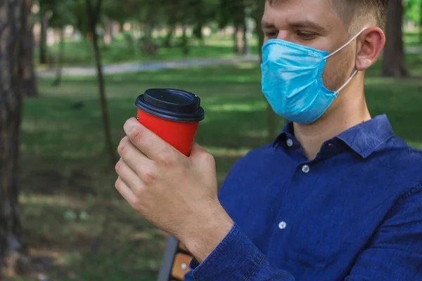 Een Man Met Een Medisch Masker Houdt Koffie Een Oranje — Stockfoto