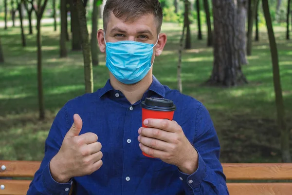 Een Man Met Een Medisch Masker Houdt Koffie Een Oranje — Stockfoto