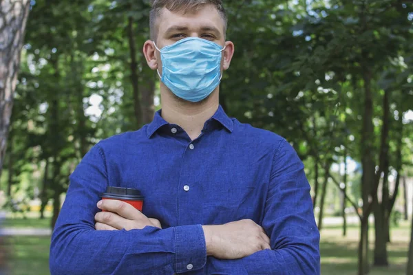 Een Man Met Een Medisch Masker Met Gevouwen Handen Houdt — Stockfoto