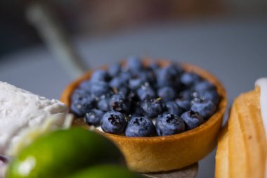 Gri masadaki yaban mersinli kısa hamurlu tatlı.