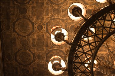 Tavanın arka planına karşı klasik tarzda bronz avize.