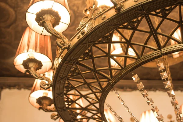 Tavanın arka planına karşı klasik tarzda bronz avize.