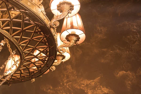 ヴィンテージスタイルの天井の背景に大きな青銅製のシャンデリア ストックフォト