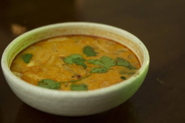 Ahşap bir masada Tom yum çorbası ile tabak
