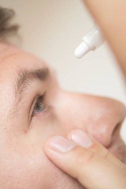 Gözlerine damla damlatıyor.