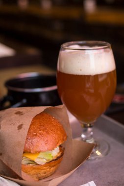 Bardakta hamburger ve bira.