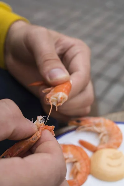 黄色いジャケットの男がエビを食べてる — ストック写真