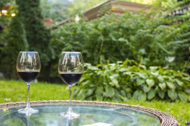 Şeffaf cam bir masada kırmızı şarap bardakları