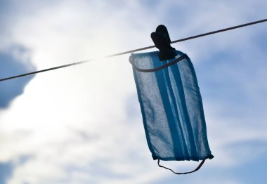 Güneş ışığıyla kuruması için tekrar kullanılmış maske. Cerrahi maske kıtlığı salgın sırasında dünyada bir sorundur..