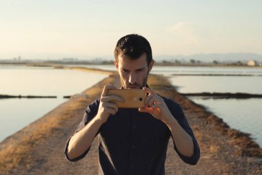 Adam gün batımında fotoğraf çekiyor.