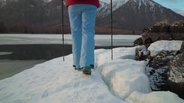 Il turista si avvicina al lago in montagna in inverno o in primavera — Video Stock