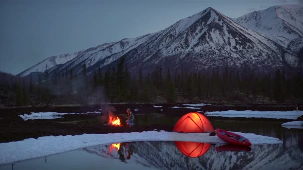 Viajante aquecendo as mãos pelo fogo no acampamento em montanhas à noite — Vídeo de Stock