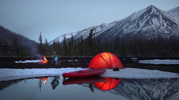 Femme assise et buvant dans un camping en montagne le soir . — Video