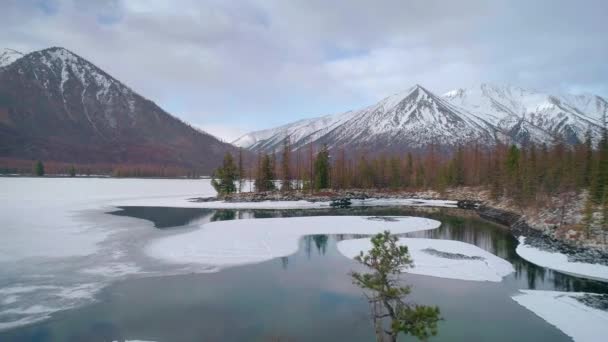 Volando sobre lagos con hielo flotante con montañas nevadas alrededor — Vídeo de stock